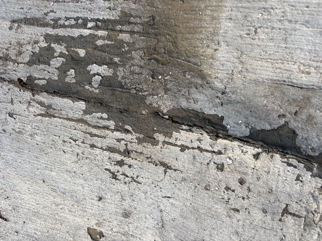 Customer close-up of the coated porch-roof seam before the proposed repair.