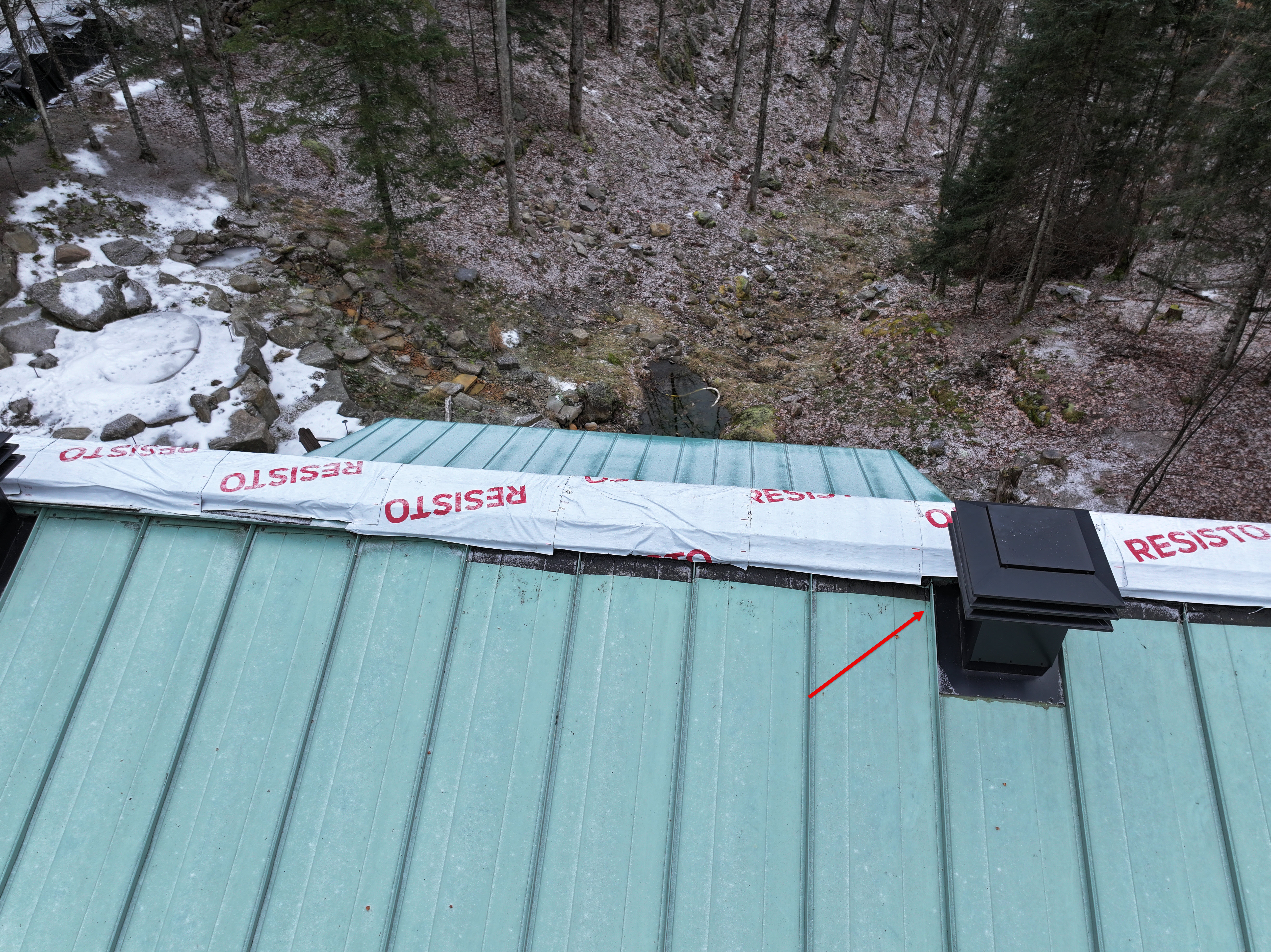 Source photo from the leak investigation. The existing arrow points to a vent considered earlier in the discussion; the leak source was not confirmed.