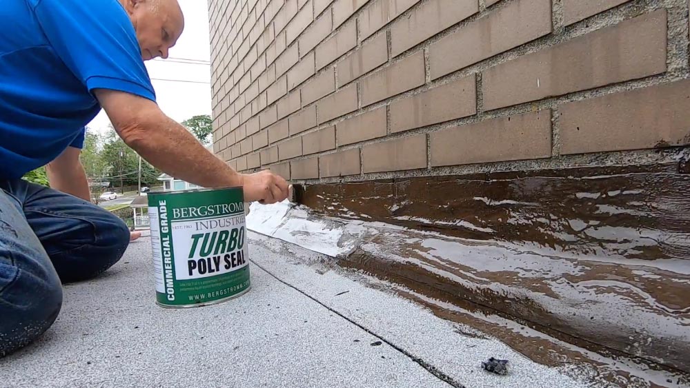 Applying Turbo Poly Seal over copper flashing and brick wall