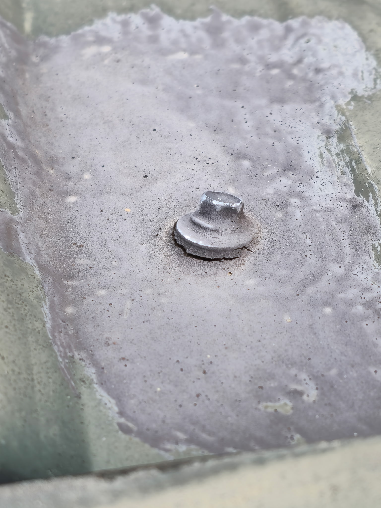 Customer photo: cracked sealant and an opening beneath one side of the roof screw washer